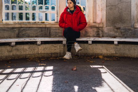 Téléchargez les photos : Femme assise jambes croisées sur un banc de pierre - en image libre de droit