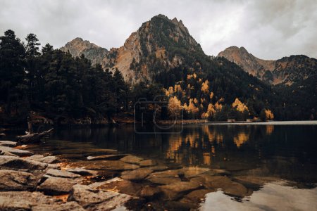 Foto de Montaña junto a un lago y algunos árboles durante un día nublado - Imagen libre de derechos