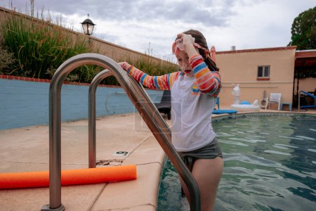 Téléchargez les photos : Enfant sortant de la piscine par une journée ensoleillée - en image libre de droit