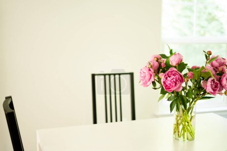 Photo for A white table with a piony's vase and   chairs - Royalty Free Image