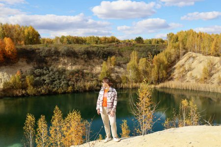Téléchargez les photos : Une femme sur le fond du paysage automnal du lac - en image libre de droit