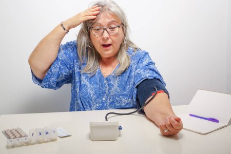 Foto de Mujer con una expresión sorprendida mientras toma una prueba de presión arterial - Imagen libre de derechos