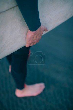Photo for Detail of a hands on a surfboard. - Royalty Free Image