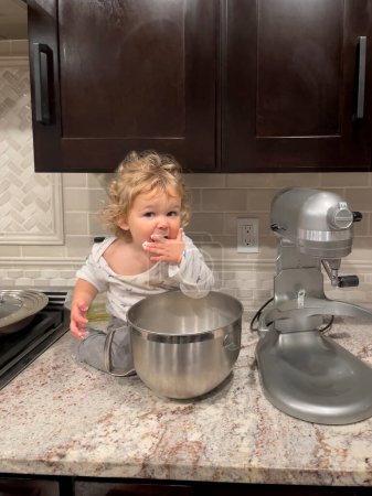 Téléchargez les photos : Les mains de tout-petit garçon couvertes de pâte souriante - en image libre de droit