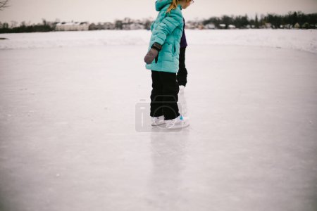 Téléchargez les photos : Patins à glace fille sur étang gelé en hiver pays des merveilles - en image libre de droit