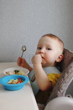 Foto de Niño sosteniendo cuchara comer verduras - Imagen libre de derechos
