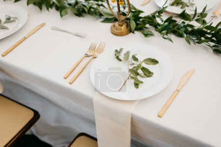 Photo for Elegant table set for a wedding meal with gold cutlery, white li - Royalty Free Image