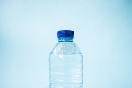 Téléchargez les photos : Bouteille d'eau en plastique sur fond bleu - en image libre de droit