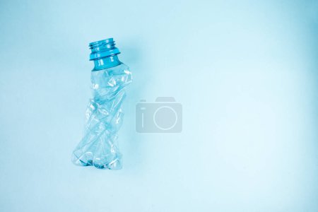 Téléchargez les photos : Gros plan de bouteille décapée en plastique sur fond bleu - en image libre de droit