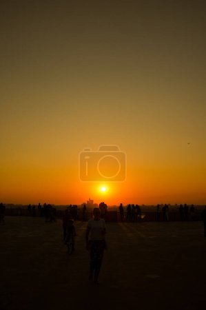 Téléchargez les photos : Silhouette d'un groupe de personnes au coucher du soleil - en image libre de droit