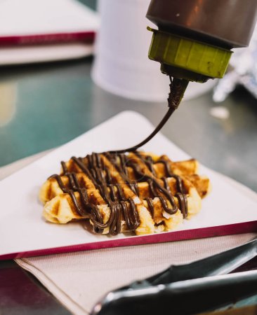 Photo for Delicious waffle with chocolate syrup to take on the go - Royalty Free Image