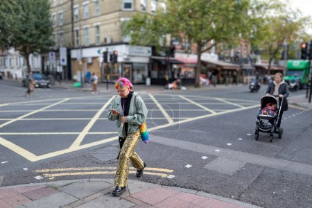 Foto de Mujer joven y colorida caminando por las calles de Cricklewood - Imagen libre de derechos