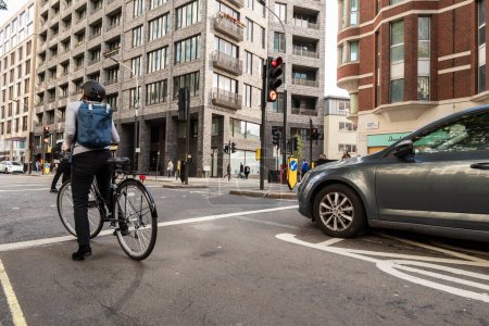 Téléchargez les photos : Vieille femme avec son vélo dans le trafic de Londres - en image libre de droit