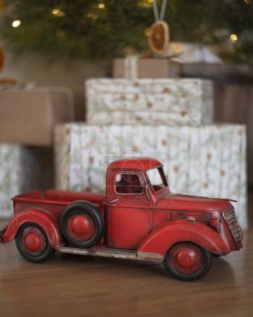 Téléchargez les photos : Camion rouge antique devant les cadeaux sous l'arbre de Noël - en image libre de droit
