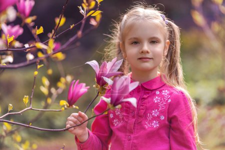 Photo for Girl holding a magnolia flower in her hand - Royalty Free Image