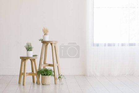 Minimale Wohnung mit Holzhockern umgeben von Zimmerpflanzen