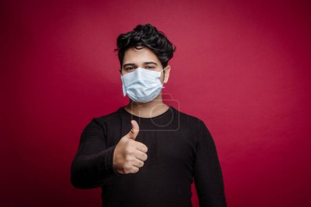 Photo for Young indian man in mask and thumbs up - Royalty Free Image