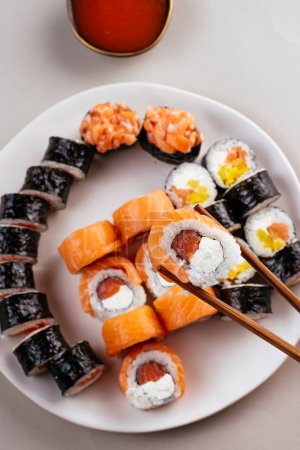 Foto de Sushi japonés con salmón y accesorios sobre la mesa - Imagen libre de derechos