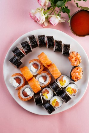 Téléchargez les photos : Sushi japonais avec saumon et accessoires sur la table - en image libre de droit