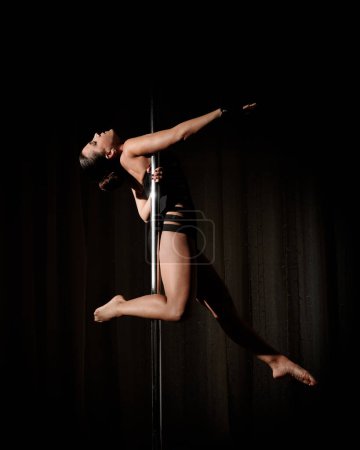 Photo for Woman does pole dance sport at home - Royalty Free Image