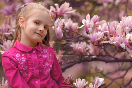 Téléchargez les photos : Fille assise dans magnolia et souriant - en image libre de droit