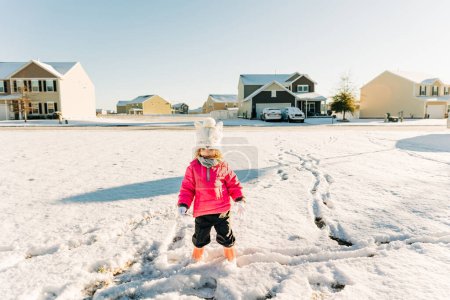 Foto de Young girl exploring snow tracks in the suburbs - Imagen libre de derechos