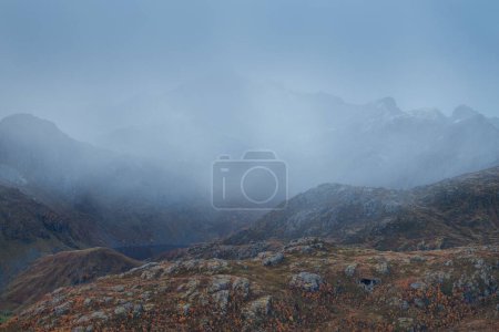Photo for Autumn snow flurry conceals mountain peaks of Vestvgy, Lofoten Islands, Norway - Royalty Free Image