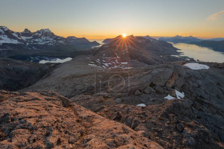Foto de Junio medianoche el sol brilla desde detrás del pico de la montaña visto desde Nesheia, Flakstady, Islas Lofoten, Noruega - Imagen libre de derechos