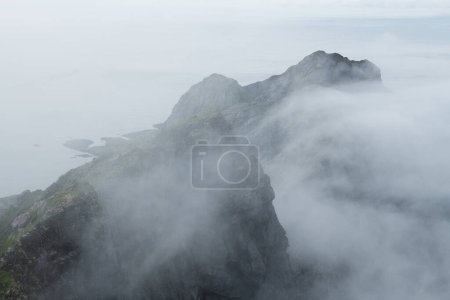 Foto de Picos de montaña nublados de Kollfjellet sobre la bahía de Buvgen, parque nacional de Lofotodden, Moskenesy, Islas Lofoten, Noruega - Imagen libre de derechos
