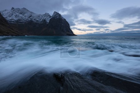 Foto de Las olas fluyen sobre la costa rocosa en la playa de Kvalvika, parque nacional de Lofotodden, Moskenesy, Islas Lofoten, Noruega - Imagen libre de derechos