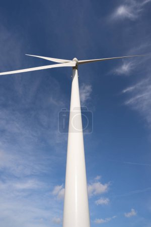 Foto de Vista de ángulo bajo de la turbina de viento girando contra el cielo azul - Imagen libre de derechos