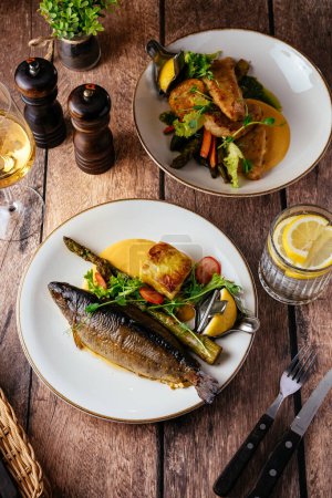 Photo for Grilled trout with vegetables and sauce on a plate, restaurant menu - Royalty Free Image