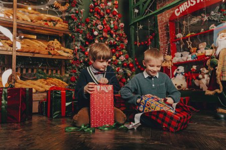 Téléchargez les photos : Garçons sous l'arbre de Noël décoré - en image libre de droit