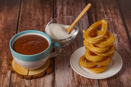 Téléchargez les photos : Chocolat chaud avec des churros dans une tasse blanche et bleue, petit déjeuner espagnol typique sur une table en bois - en image libre de droit