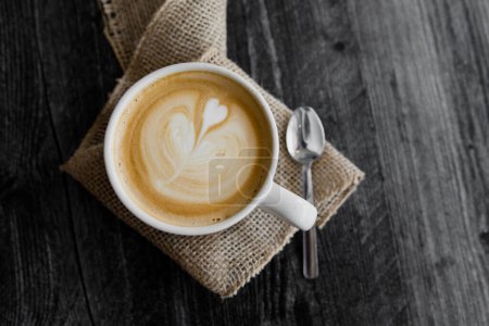 Foto de Diseño del corazón latte en taza en arpillera - Imagen libre de derechos