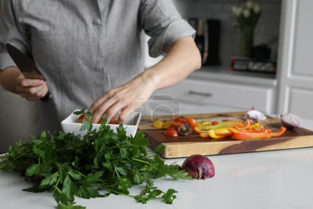 Téléchargez les photos : Homme Préparation de légumes au persil et tomates - en image libre de droit