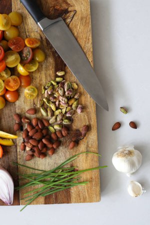 Photo for Cutting board with nuts and tomatoes - Royalty Free Image