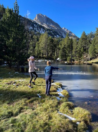Photo for Icy lake in Benasque valley. Children playing with the ice - Royalty Free Image