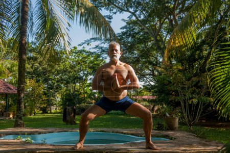 Téléchargez les photos : Attractive mature caucasian man performs isometric exercises - en image libre de droit