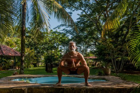 Téléchargez les photos : Attractive mature caucasian man performs isometric exercises - en image libre de droit