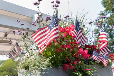 Foto de American flags interspersed among summer flowers - Imagen libre de derechos