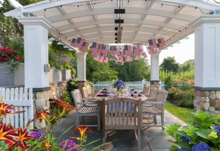 Festive Fourth of July party table set under garden pergola
