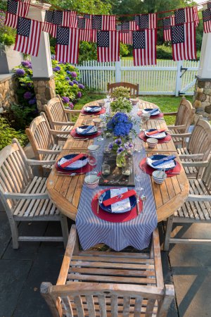 Foto de Festive Fourth of July party table set under garden pergola - Imagen libre de derechos