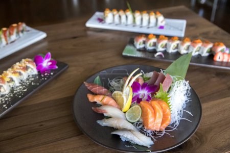 Téléchargez les photos : Colorful plates of sashimi and sushi at an Asian seafood restuarant - en image libre de droit
