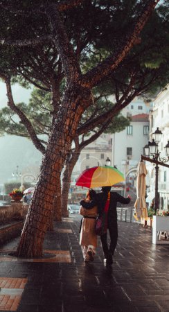 Photo for Couple under an umbrella strolling along the amalfi coast - Royalty Free Image