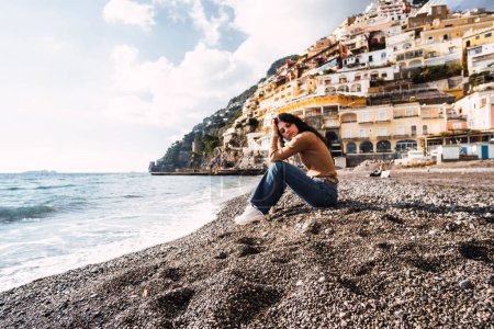 Foto de Woman on black stone beach of positano - Imagen libre de derechos