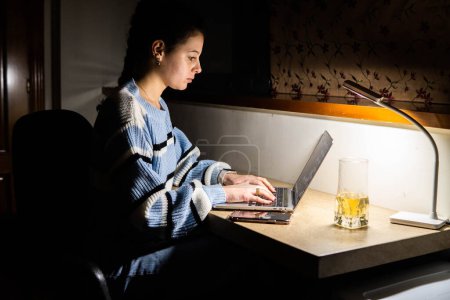 Photo for Girl working on computer at home at night - Royalty Free Image