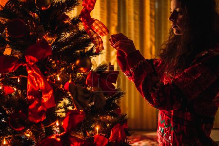 Foto de Mujer decorando el árbol de Navidad en casa - Imagen libre de derechos