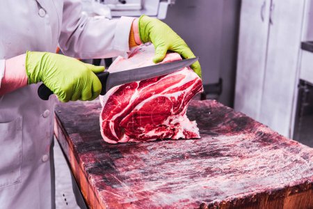 Photo for Butcher cutting a ribeye with the knife - Royalty Free Image