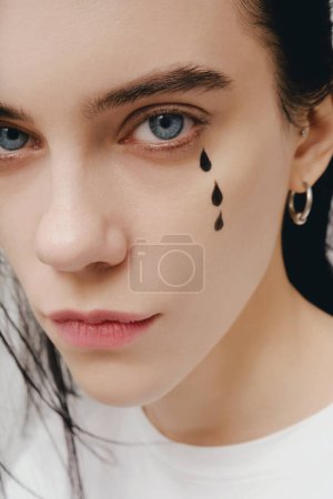 Téléchargez les photos : Portriat en gros plan d'une femme en pleurs avec un maquillage fluide - en image libre de droit
